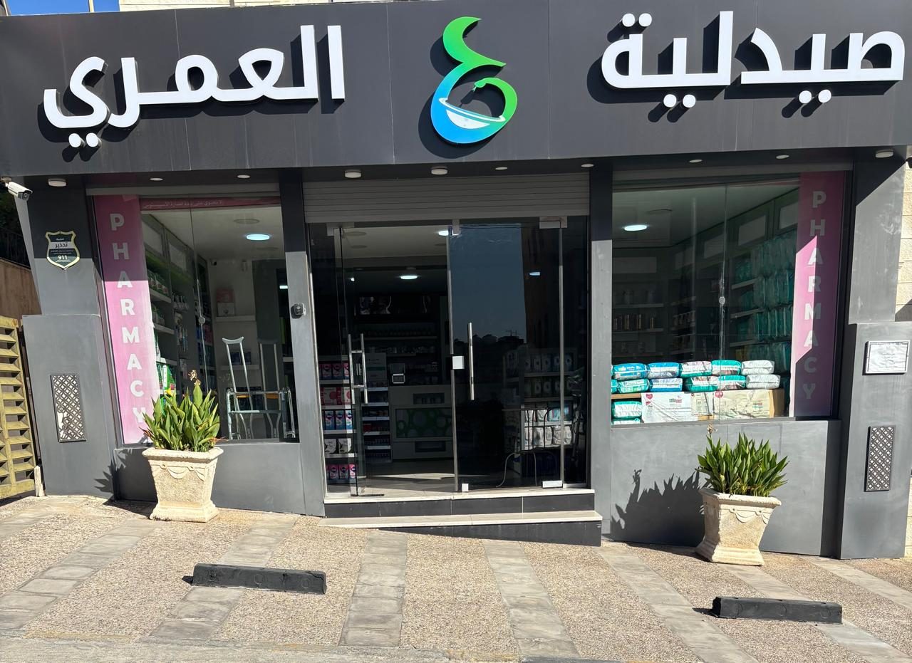Al Omari Pharmacy storefront in daylight, Arabic signage above the entrance
