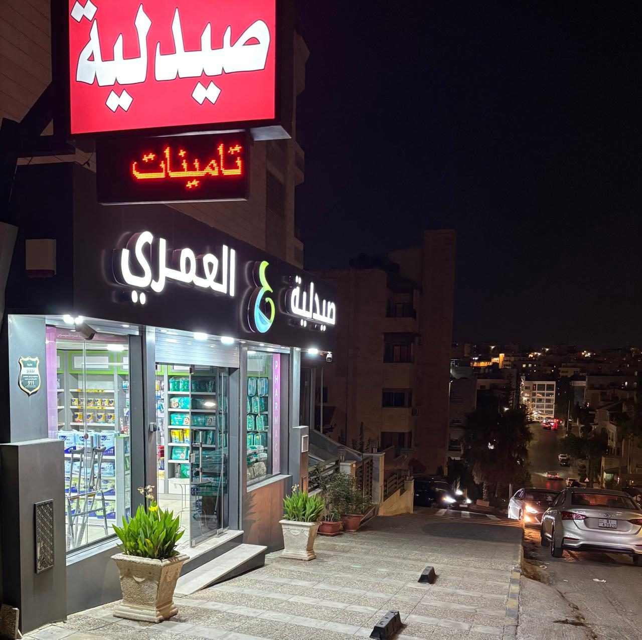 Illuminated red and blue pharmacy sign at night