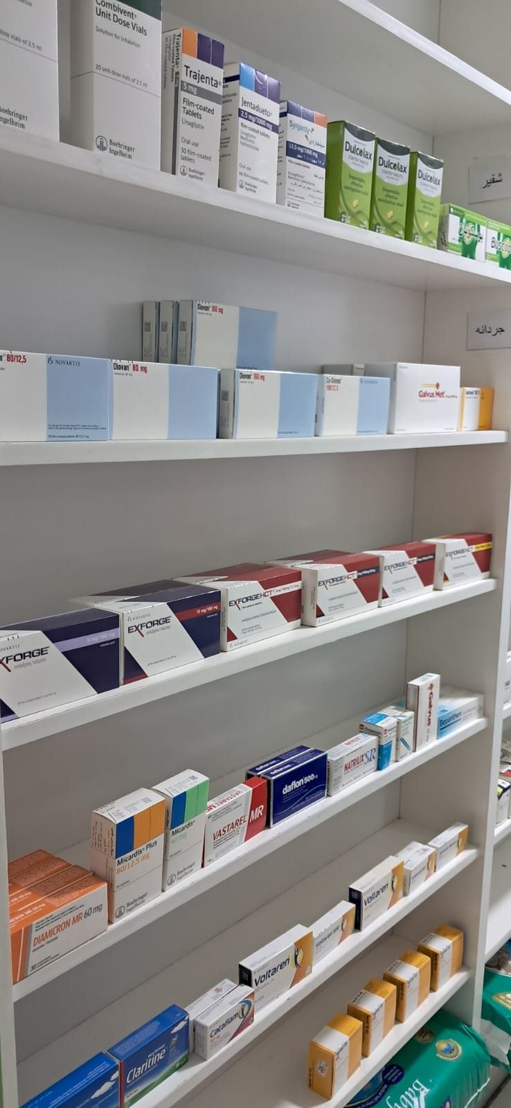 Stocked pharmacy shelves seen from the aisle